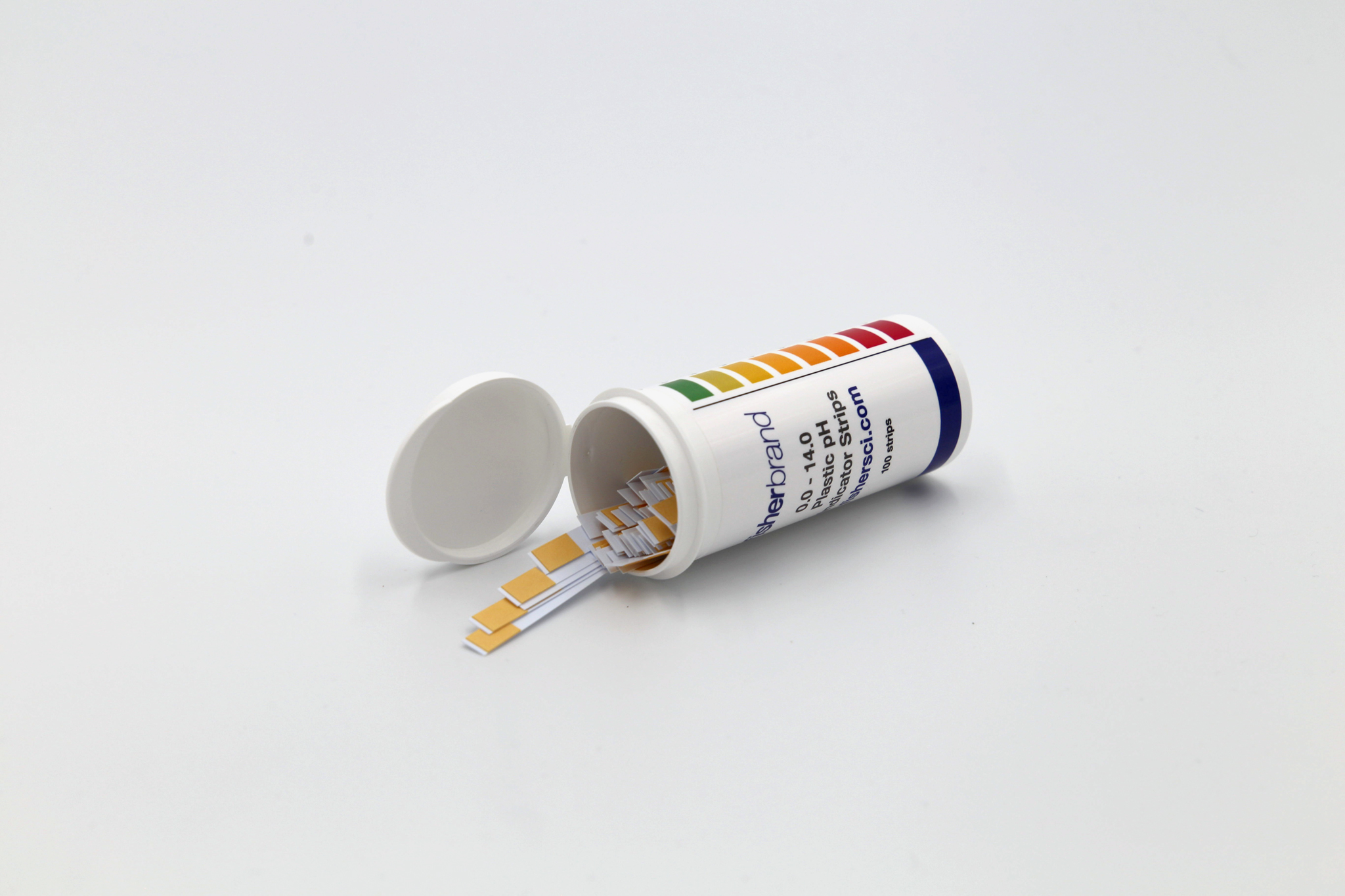 Small opened canister of ph strips on a white background