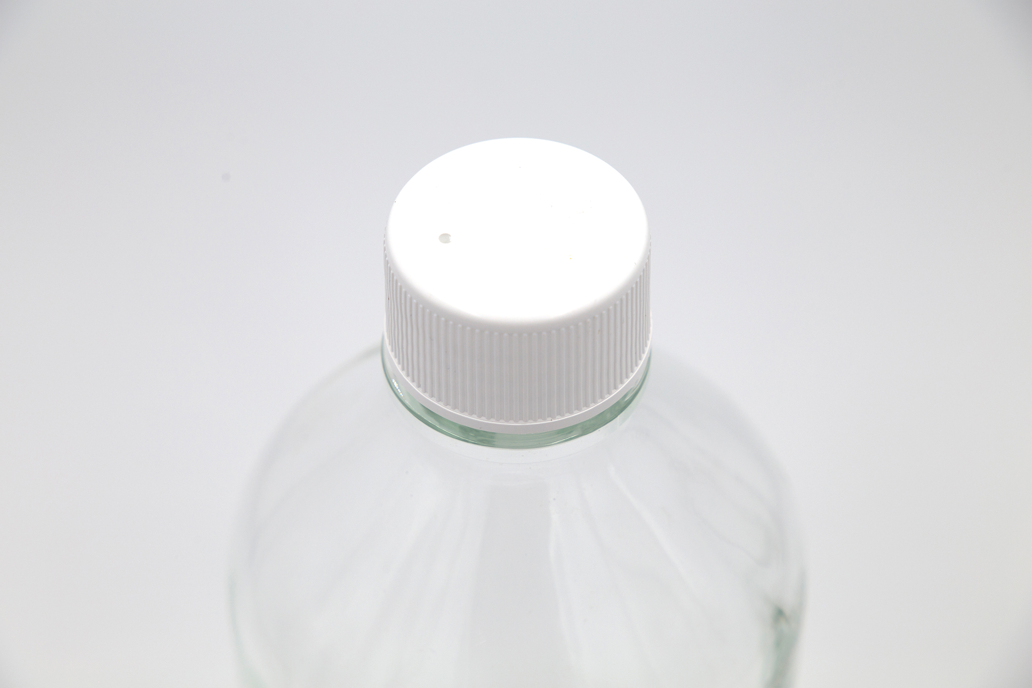 White cap on glass bottle over white background